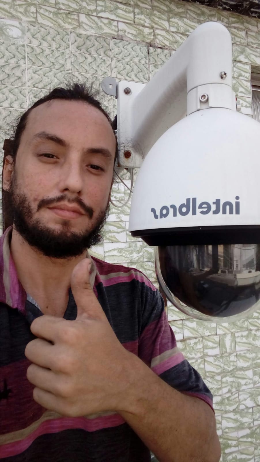Foto do acervo de trabalho junto a uma câmera de videomonitoramento.