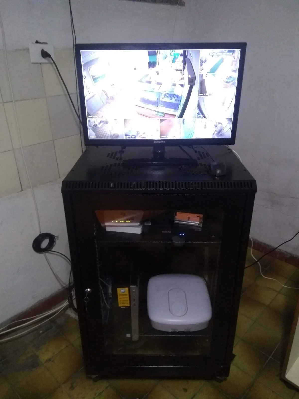Montagem de rack com equipamentos de rede, central de alarme e sistema de CFTV em uma loja Megamatte.